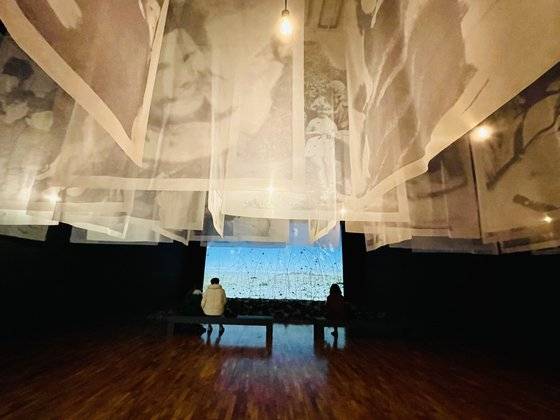 볼탕스키의‘아니미타스’가 상영되고 있는 부산시립미술관 전시장. 맑은 풍경소리가 들리는 가운데 관람객들이 작품을 보고 있다. 이은주 기자