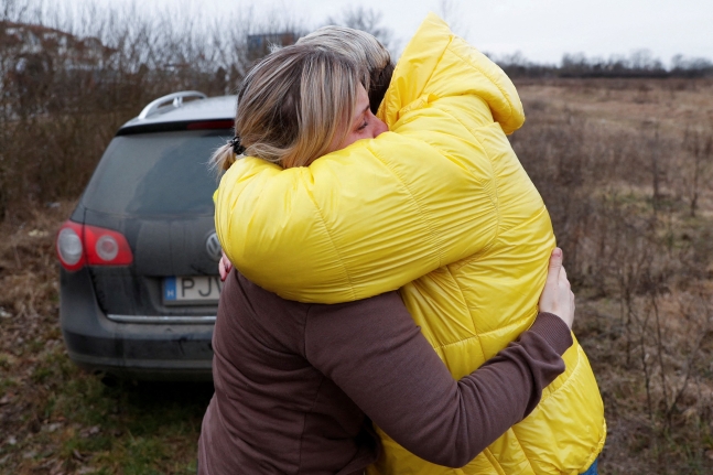 안나 세먹이 자신의 아이들을 데리고 안전하게 우크라이나 국경을 넘은 나탈리야 아브레예바(58)와 함께 눈물을 흘리고 있다. 이들은 이날 처음 만났다. 로이터통신 연합뉴스