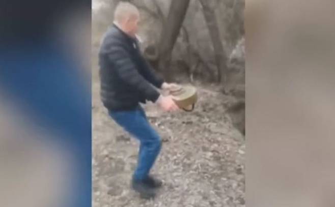 우크라이나에서 한 남성이 담배를 문 채 맨손으로 도로에 놓여있던 대전차 지뢰를 숲으로 옮기도 있다. 출처: 데일리메일 *재판매 및 DB 금지