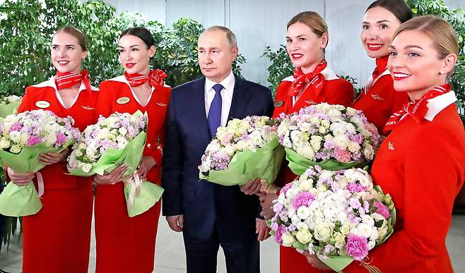 블라디미르 푸틴 러시아 대통령이 5일 세계 여성의 날(8일)을 앞두고 모스크바 근교에 있는 국영항공사 아에로플로트 항공학교를 방문해 여승무원과 기념사진을 찍고 있다. 로이터=연합뉴스