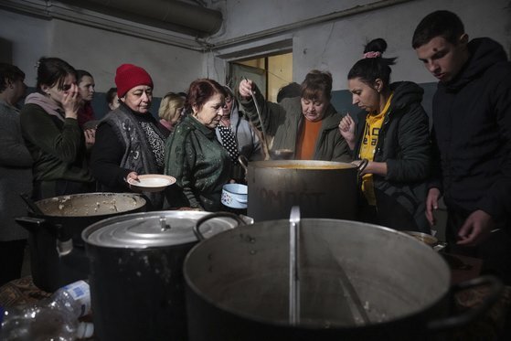 7일 마리우폴 임시 대피소에서 음식을 받기 위해 줄 서 있는 사람들의 모습. [AP=연합뉴스]