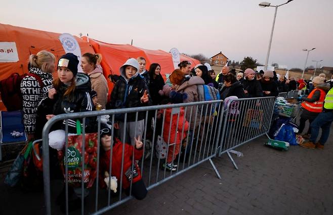 지난 13일(현지시간) 폴란드 남동부 메디카의 검문소에서 국경을 넘어 온 우크라이나 피란민이 줄지어 버스를 기다리고 있다. 유엔난민기구(UNHCR)에 따르면 러시아군 침공 이후 전날까지 국외로 탈출한 우크라이나 난민 수가 260만 명을 넘어섰으며, 이 중 160만 명이 폴란드로 향한 것으로 집계됐다. 연합뉴스