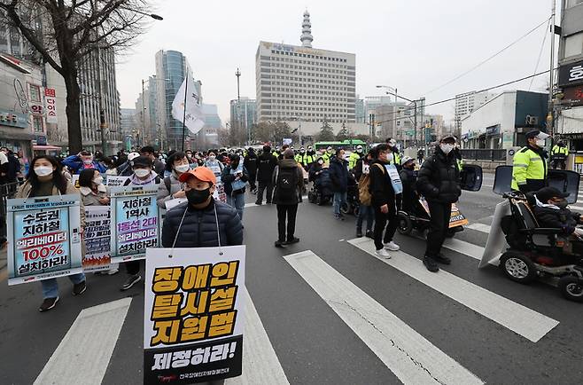 전국장애인차별철폐연대 등 장애인단체 회원들이 지난 25일 서울 종로구 경복궁역 인근에서 대통령직인수위원회에 장애인 이동권과 교육권, 노동권, 탈시설 권리, 장애인권리예산 보장 등을 촉구하며 행진하고 있다. 연합뉴스