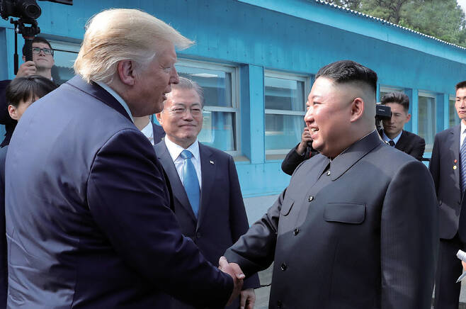 도널드 트럼프 미국 대통령과 김정은 북한 국무위원장이 2019년 6월30일 판문점에서 악수 하고 있다. 문재인 대통령이 이를 바라보고 있다.ⓒ조선중앙통신 연합