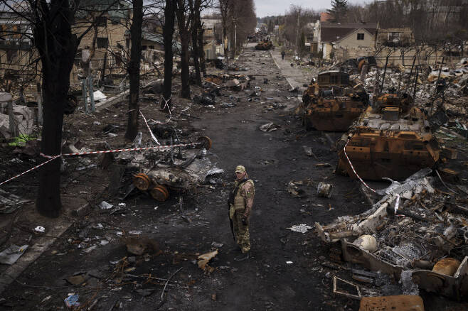 우크라이나 병사가 6일(현지시간) 수도 키이우(키예프) 외곽 소도시 부차에서 파괴된 러시아군 탱크들이 널부러져 있는 거리 한복판에 서 있다. AP연합뉴스