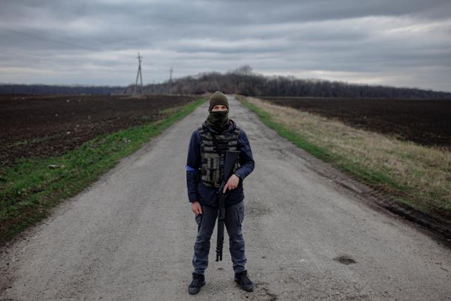 우크라이나 북동부 하르키우 외곽의 한 농부가 지난 3일 무장을 하고 총을 든 채 들판에 서 있다. 우크라이나 농부들이 러시아군을 막기 위해 총을 들고 싸우면서 밀 수출과 옥수수 파종도 제때 이뤄지지 않고 있다. 하르키우=로이터 연합뉴스