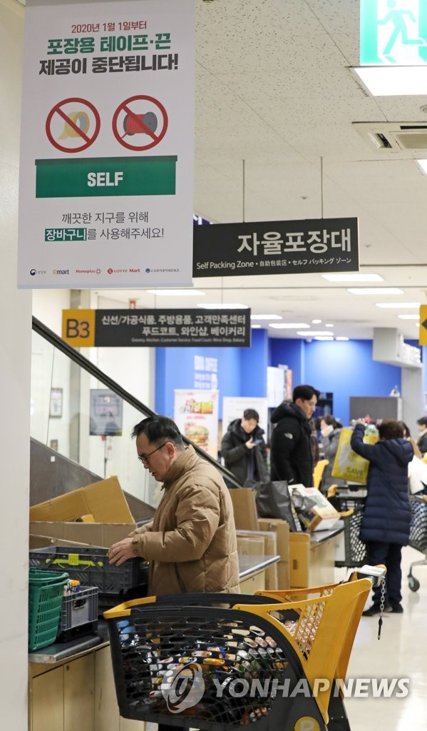 대형마트 자율포장대에서 포장용 테이프와 끈 제공이 중단된 2020년 1월 서울 시내의 한 대형마트에서 시민들이 미리 준비한 장바구니에 구매한 물품을 옮겨 담고 있다./연합뉴스