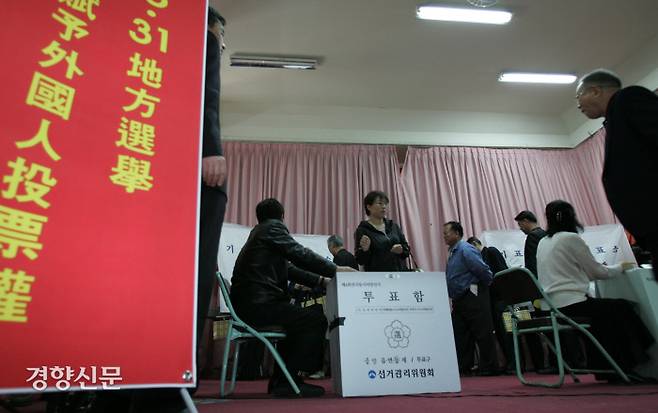 처음으로 지방선거 선거권이 주어진 외국인들이 2006년 4월 15일 서울 중구 한성 화교소학교에서 열린 투표시연회에서 관계자의 안내를 받으며 모의 투표를 하고 있다. / 김문석 기자