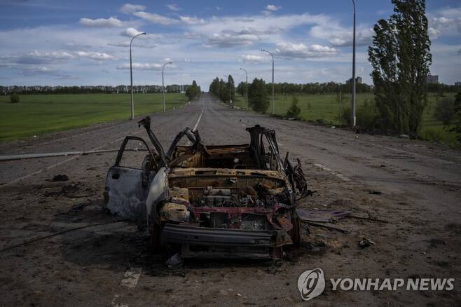 13일(현지시간) 우크라이나 동부 하르키우의 한 도로에 파괴된 차량의 잔해가 방치돼 있다. [AP=연합뉴스 자료사진. 재판매 및 DB 금지]