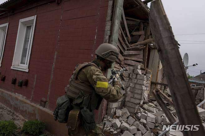 [하르키우=AP/뉴시스] 14일(현지시간) 우크라이나군 병사가 러시아군으로부터 탈환한 동부 하르키우 외곽의 마을에서 정찰 임무를 수행하고 있다. 2022.05.15.