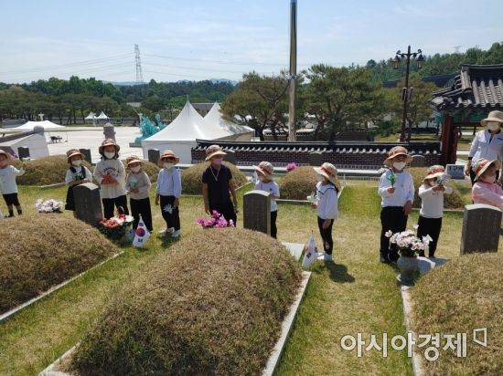 16일 오전 광주 인양유치원생들이 고사리손으로 518민주영령들에 헌화하고 있다.