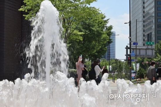 서울 낮 최고기온이 23도까지 오르는 등 초여름 날씨를 보인 15일 서울광장을 찾은 외국인 관광객들이 시원하게 뿜어내는 분수를 배경으로 기념사진을 찍고 있다./윤동주 기자 doso7@