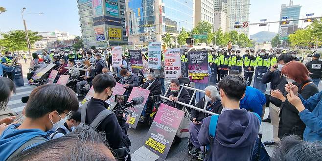 전국장애인차별철폐연대 회원들이 16일 오전 서울 신용산역 4호선 3번 출구 앞 횡단보도 앞에서 삼각지역까지 '장애인 권리예산 22년 추경 반영을 위한 긴급행동' 행진 시위를 진행하고 있다. /뉴스1