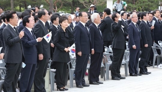 박근혜 전 대통령이 2013년 5월18일 5·18 민주화운동 기념식에 참석해 ‘임을 위한 행진곡’이 울러퍼질 때 태극기만 손에 쥔 채 노래를 부르지 않고 있다. <한겨레> 자료 사진
