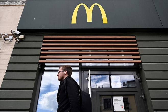 16일 러시아 수도 모스크바에 있는 문을 닫은 맥도날드 점포 앞을 남성 한 명이 지나가고 있다. AFP 연합뉴스