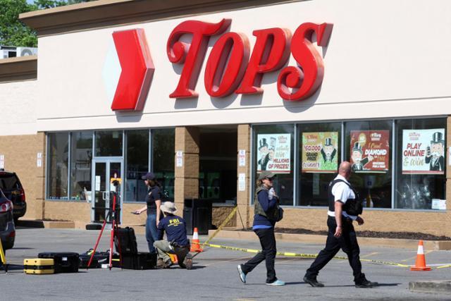 총기난사 사건이 발생한 미국 뉴욕주 버펄로의 '톱스' 슈퍼마켓에서 15일 경찰과 연방수사국 관계자들이 조사를 하고 있다. 버펄로=로이터 연합뉴스