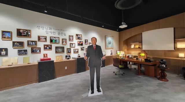 15일 문을 연 여의도순복음교회 1층 조용기 목사 기념홀 내부에 꾸며진 조 목사 집무실 전경. 실물 크기의 조 목사 사진 뒤편으로 해외성회 사역 현장 등에서 찍은 사진들이 걸려 있다. 오른쪽엔 생전에 업무를 보던 책상과 의자, 각종 집기들이 전시돼 있다. 여의도순복음교회 제공