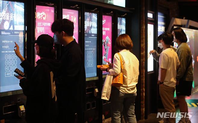 [서울=뉴시스] 55세 이상 고령층의 54%가 키오스크를 사용해보지 않은 것으로 조사됐다. 또 고령층의 20%가 디지털 기기 및 서비스 이용 시 발생한 어려움을 해결하지 못한 것으로 나타났다. 사진은 지난 9일 오후 서울 시내 영화관에서 시민들이 영화를 보기 위해 키오스크에서 결제하는 모습. (사진=뉴시스DB) photo@newsis.com