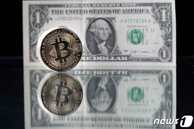 2021년 4월 26일(현지시간) 파리에서 찍힌 미국 1달러 지폐와 비트코인의 이미지를 담은 모조품. © AFP=뉴스1 © News1 김지현 기자