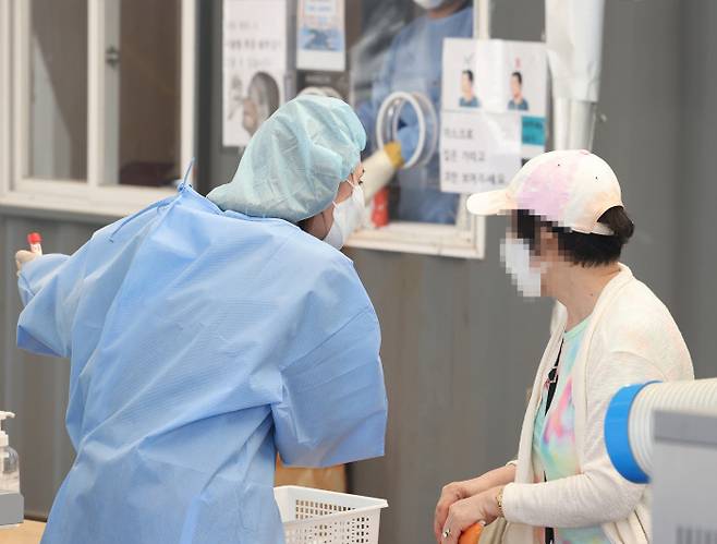 지난 16일 오전 서울 중구 서울역 코로나19 선별검사소에서 한 시민이 PCR 검사를 하기 위해 안내를 받고 있다. 연합뉴스