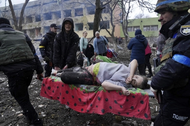 지난 3월 9일(현지시간) 러시아군 폭격으로 파괴된 우크라이나 남부 항구도시 마리우폴 시내의 한 산부인과에서 만삭 임산부가 들것에 실려 이송되고 있다. 이 산모는 며칠 후 배 속 아기와 함께 끝내 숨졌다./AP연합뉴스
