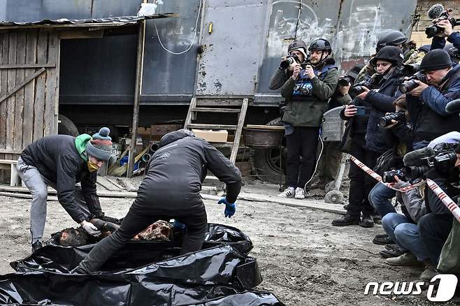 지난달 우크라이나 군이 탈환한 키이우 인근 부차에서 취재진이 참석한 가운데 러시아 군에 학살 당한 민간인 시신을 수습하던 모습. © AFP=뉴스1 © News1 우동명 기자