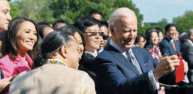 백악관서 아시아인·태평양계 미국인 초청 행사 - 조 바이든 미국 대통령이 17일(현지 시각) 미 워싱턴 DC 백악관 로즈 가든에서 열린 아시아인·태평양계 미국인 문화유산의 달 기념 행사에서 참석자들과 함께 사진을 찍고 있다. 바이든 대통령은 이날 연설에서 최근 발생한 캘리포니아 교회와 뉴욕 식료품점 총기 난사 사건을 언급하며 “증오를 어떻게 끝낼 것인지뿐만 아니라 증오를 발생시킨 책임이 누구에게 있는지에 관해서도 얘기해야 된다”고 말했다. /AFP 연합뉴스