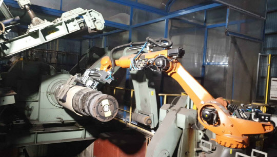 포스코 제철소에 적용된 슬라브 인출 로봇이 현장 작업을 하고 있다. <포스코ICT 제공>