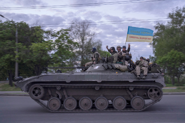 우크라이나 동북부 하르키우 시내를 지나는 장갑차에 올라탄 우크라이나 군인들이 17일(현지시간) 손을 흔들고 있다. 장갑차에 꽂힌 우크라이나 국기에는 ‘적에게는 죽음을, 우크라이나에는 영광을’이라는 문구가 적혀 있다. AP연합뉴스