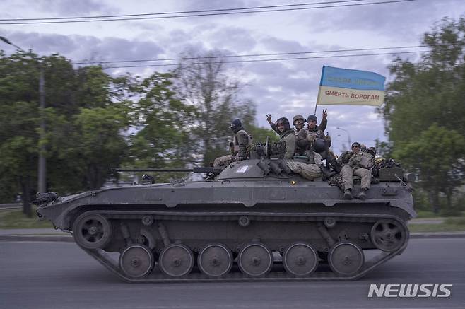 [하르키우=AP/뉴시스]지난 16일(현지시간) 우크라이나 동부 하르키우에서 우크라이나 군인들이 "우크라이나에 영광을" "적에게 죽음을"이라고 쓰인 깃발을 단 전차에 올라 손을 흔들며 도로를 지나고 있다. 2022.05.19.
