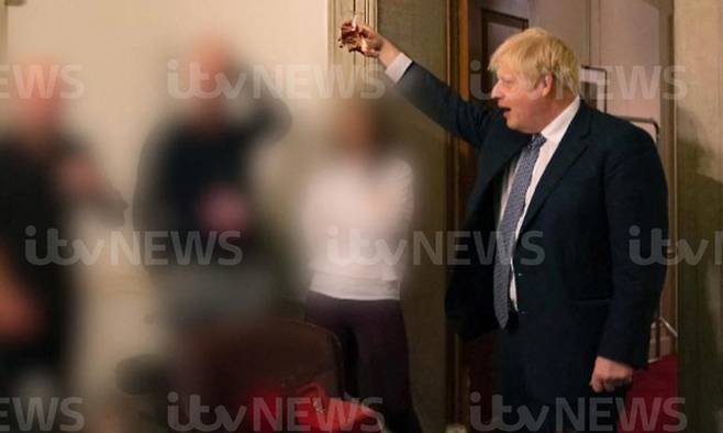보리스 존슨 영국 총리가 코로나19 봉쇄조치로 타인과의 모임이 금지됐던 2020년 11월 총리관저에서 열린 직원 송별파티 도중 술잔을 높이 들고 건배하는 사진을 영국 ITV가 23일(현시시간) 공개했다. ITV 뉴스 캡처