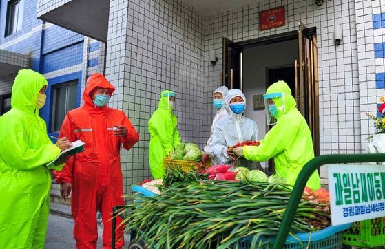 '코로나19 봉쇄' 가정에 식료품을 전달하는 북한 일꾼. 뉴스1