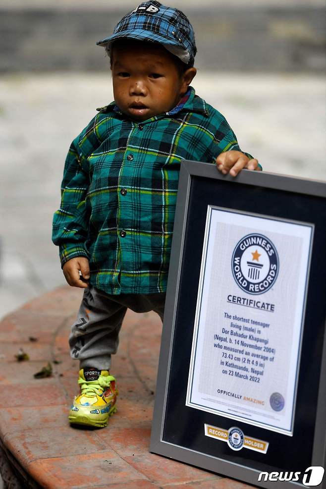 24일(현지시간) 네팔 카트만두에서 도르 바하두르 카판지가 기네스 세계 기록 인증서를 옆에 두고 포즈를 취하고 있다 © AFP=뉴스1