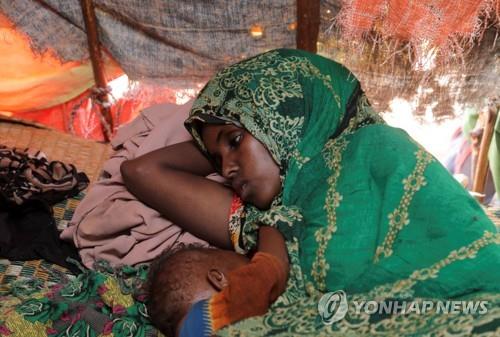 소말리아 기아 (돌로우 로이터=연합뉴스) 24일(현지시각) 소말리아 게도 지역 돌로우의 국내 난민을 위한 칵사리 캠프에서 압디아 아덴 모하메드가 8개월 된 아이와 임시 보호소에서 쉬고 있다. 2022.5.25 photo@yna.co.kr