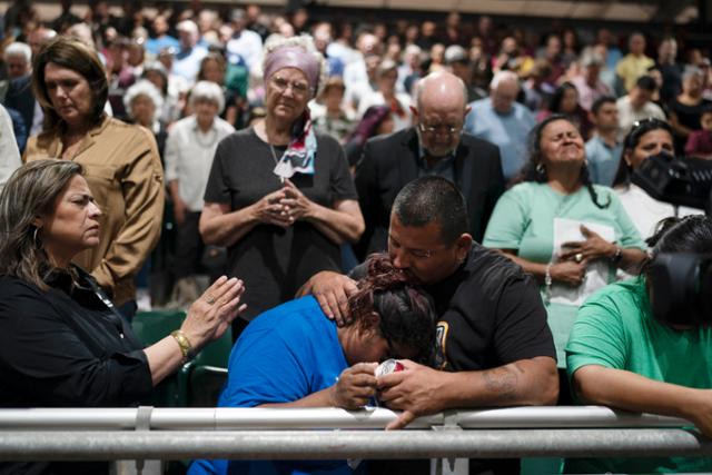 25일 미국 텍사스주 유밸디 롭 초등학교 총기 난사 사건의 피해자 가족이 추모행사에서 서로를 끌어안고 있다. AP 연합뉴스