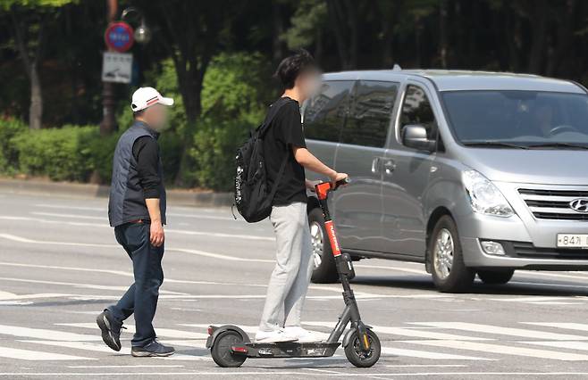 경기 수원시의 한 거리에서 전동킥보드 이용자가 안전모를 쓰지 않고 주행을 하고 있다. /뉴스1