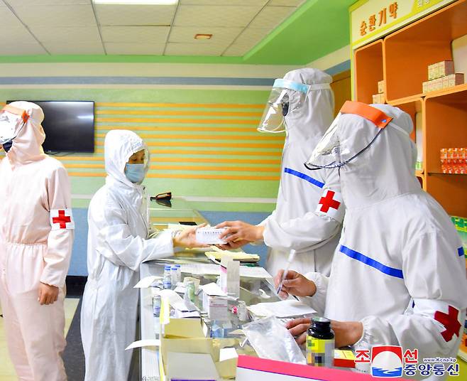 A photo released by the North Korean Central News Agency (KCNA) on 20 Mayshows medical service personnel in the military handing out medical supplies at a pharmacy to curb the current coronavirus disease health crisis in Pyongyang, North Korea. (Yonhap)