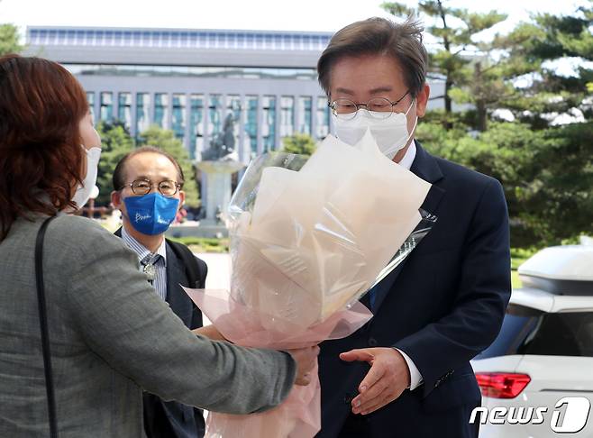 이재명 더불어민주당 의원이 7일 오전 서울 여의도 국회의원회관에 도착해 지지자로부터 꽃다발을 받고 있다. (공동취재) 2022.6.7/뉴스1 © News1 이재명 기자