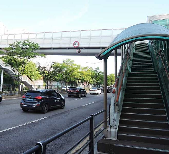 지난 8일 오전 7시쯤 경기도 수원의 8차선 덕영대로를 차들이 달리고 있다. 육교 하단에는 속도제한 시속 50km를 알리는 교통안내표지가 붙어 있다. /배준용 기자