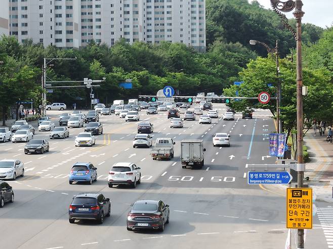 지난 8일 오전 8시 30분쯤 경기도 수원 왕복 10차로 봉영로에서 차들이 달리는 모습. 신호등에는 시속 50km 속도제한 표지판이 붙어있다./배준용 기자