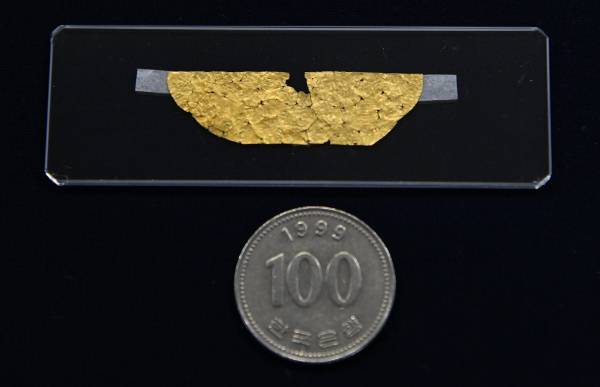 유물의 크기를 가늠하도록 100원 동전과 비교한 모습. 문화재청 제공