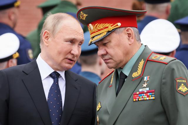 블라디미르 푸틴(왼쪽) 러시아 대통령이 22일(현지시간) 나치의 옛 소련 침공 81주년을 맞아 모스크바의 무명용사 묘소를 찾은 후 세르게이 쇼이구 국방장관과 얘기하고 있다. 모스크바=AP 뉴시스