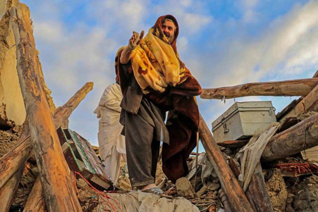 아프가니스탄 지진 피해 주민들이 23일 파크티카주 가얀 마을의 건물 잔해 속에서 구호를 기다리고 있다. 가얀=EPA 연합뉴스