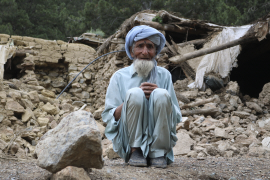 22일(현지시간) 아프가니스탄 남동부 파크티카주에서 발생한 강진으로 가옥과 인명 피해가 대규모로 발생한 가운데 한 노인이 허물어진 주택 앞에 주저 앉아 있다. 연합뉴스·AFP