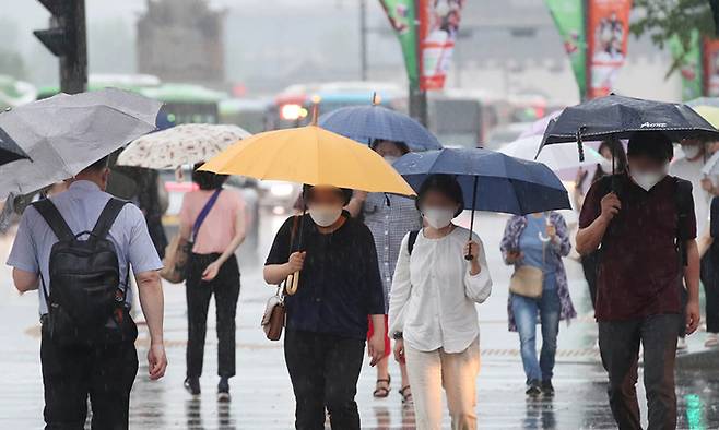 전국 곳곳에 장맛비가 내리기 시작한 23일 서울 광화문에서 시민들이 우산을 쓴 채 걸어가고 있다. 서상배 선임기자