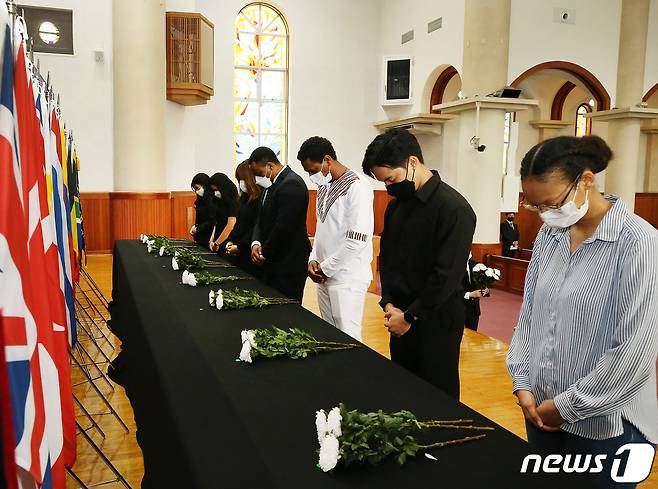 24일 오전 대구 달서구 계명대학교 성서캠퍼스에서 열린 추념식에서 16개국 참전국의 유학생들이 각 나라 국기 앞에 헌화한 뒤 희생자를 위로하는 묵념을 하고 있다. (계명대 제공) 2022.6.24/뉴스1 © News1 공정식 기자
