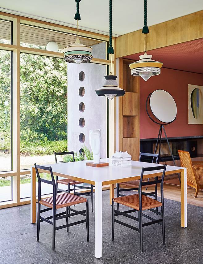 빈센트 반 두이센(Vicent van Duysen)이 디자인한 테이블과 의자를 둔 다이닝 룸. 의자는 지오 폰티(Gio Ponti)의 ‘슈퍼레제라(Superleggera)’. 단순한 형태로 공간에 힘을 더하는 세 개의 우아한 램프 ‘칼리스포 마르티니크(Calyspo Martinique)’는 콘타르디(Contardi) 제품.