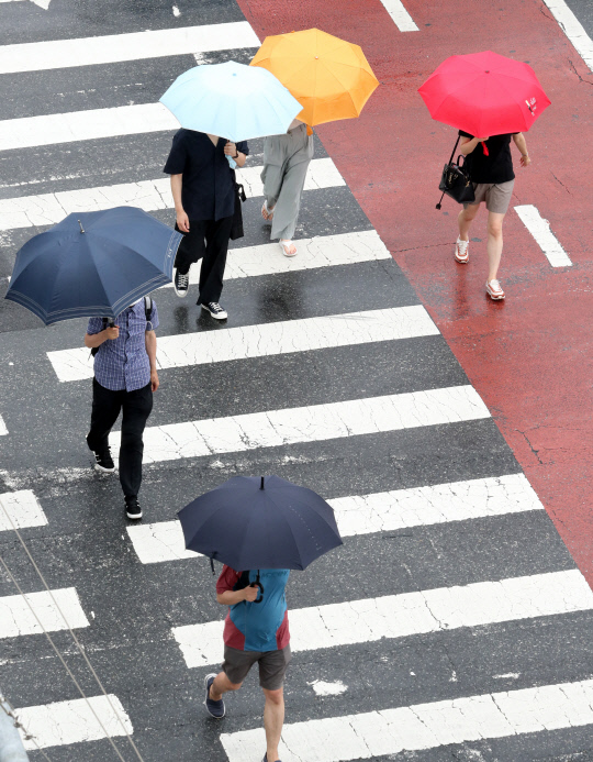 전국적으로 장맛비가 내린 지난 23일 대전 유성구네거리에서 시민들이 우산을 쓴 채 횡단보도를 건너고 있다. 최은성 기자