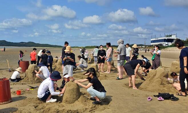 지난 18일 신두리 해수욕장에서 관광객들이 모래조각을 만들고 있다. 태안군 제공