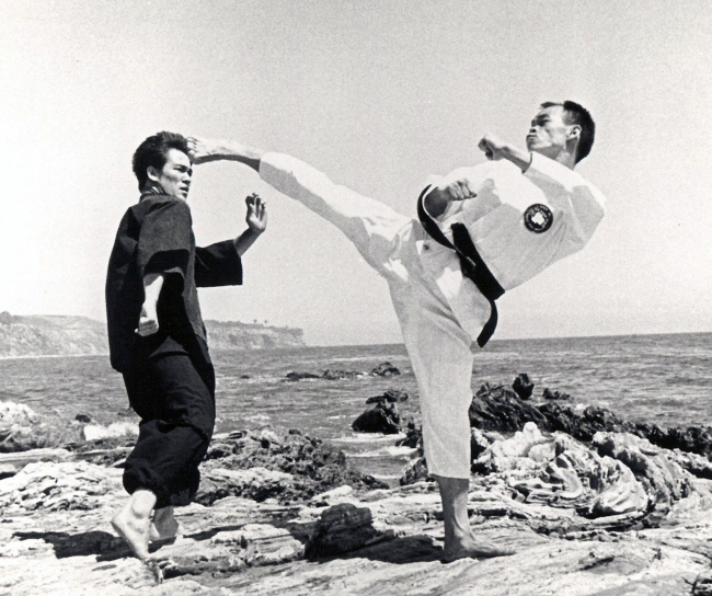 미국 태권도의 대부 이준구(오른쪽) 사범이 1968년 로스앤젤레스(LA) 해변에서 액션 스타 이소룡에게 태권도 발차기 기술을 가르치고 있다.  자료사진